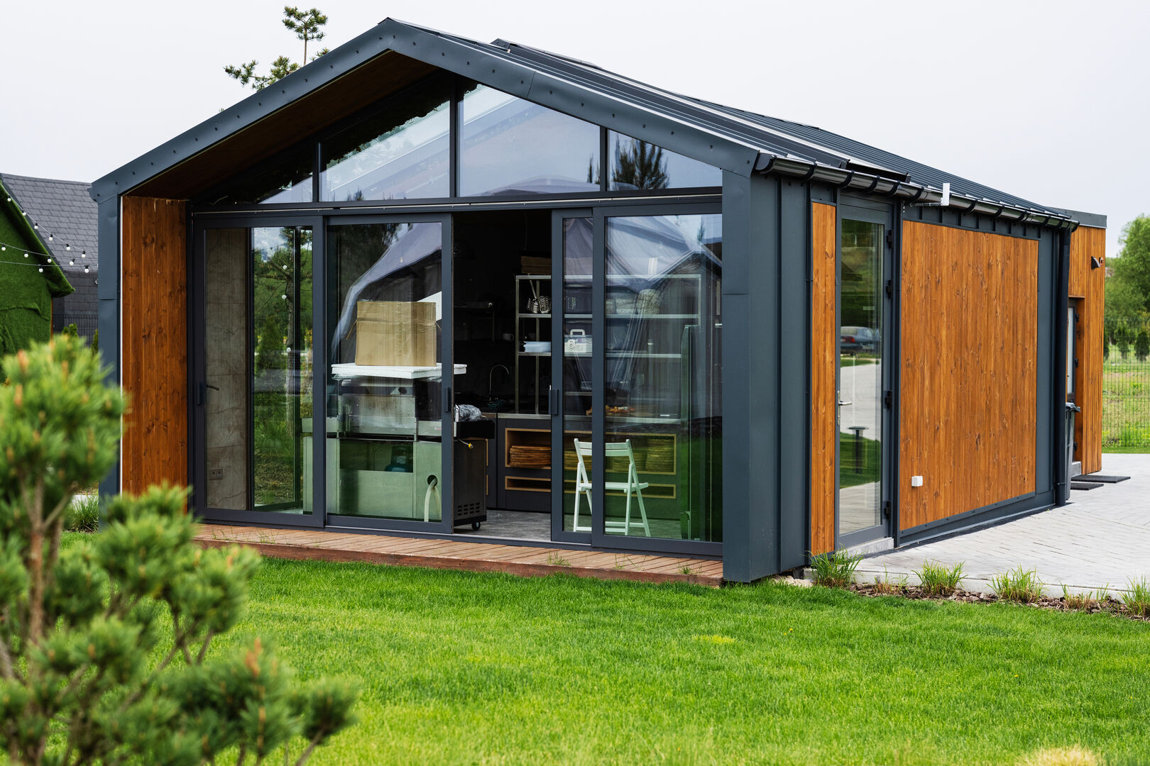 Modern tiny house with glass facade and wooden exterior