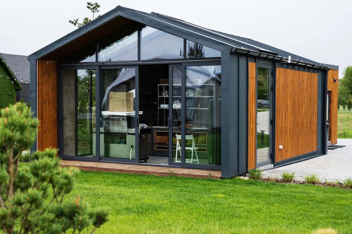Modern tiny house with glass facade and wooden exterior
