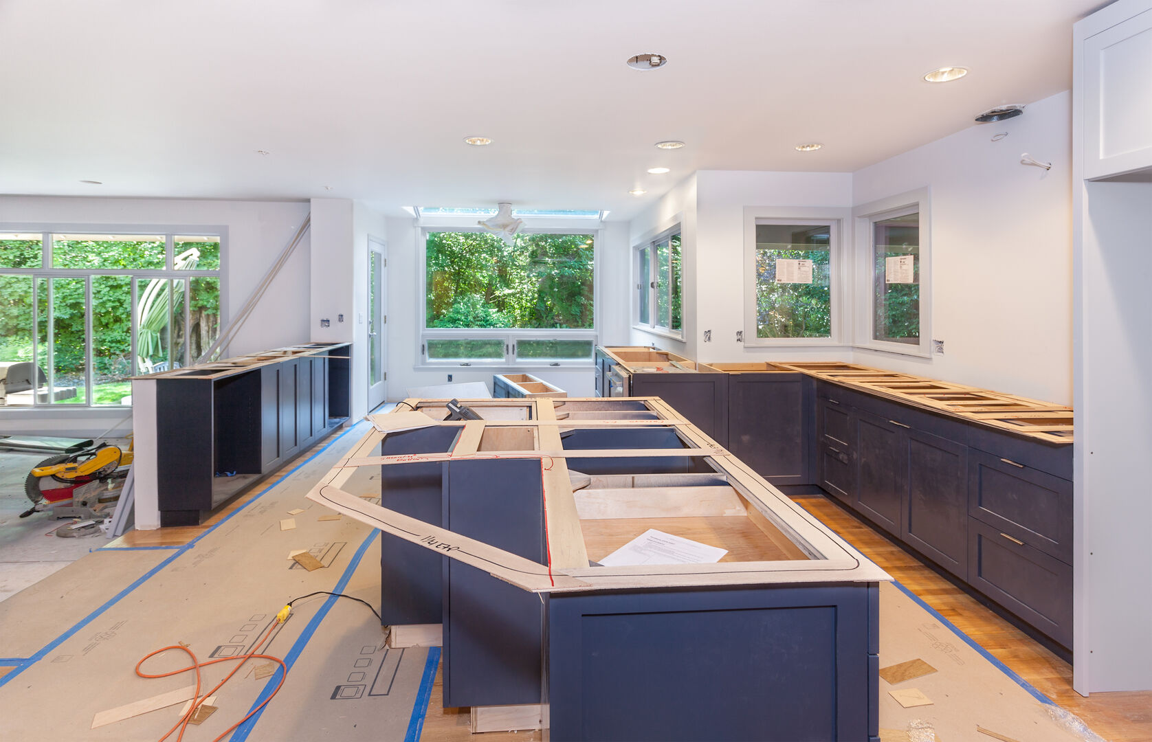 Modern open concept kitchen renovation with blue cabinet.