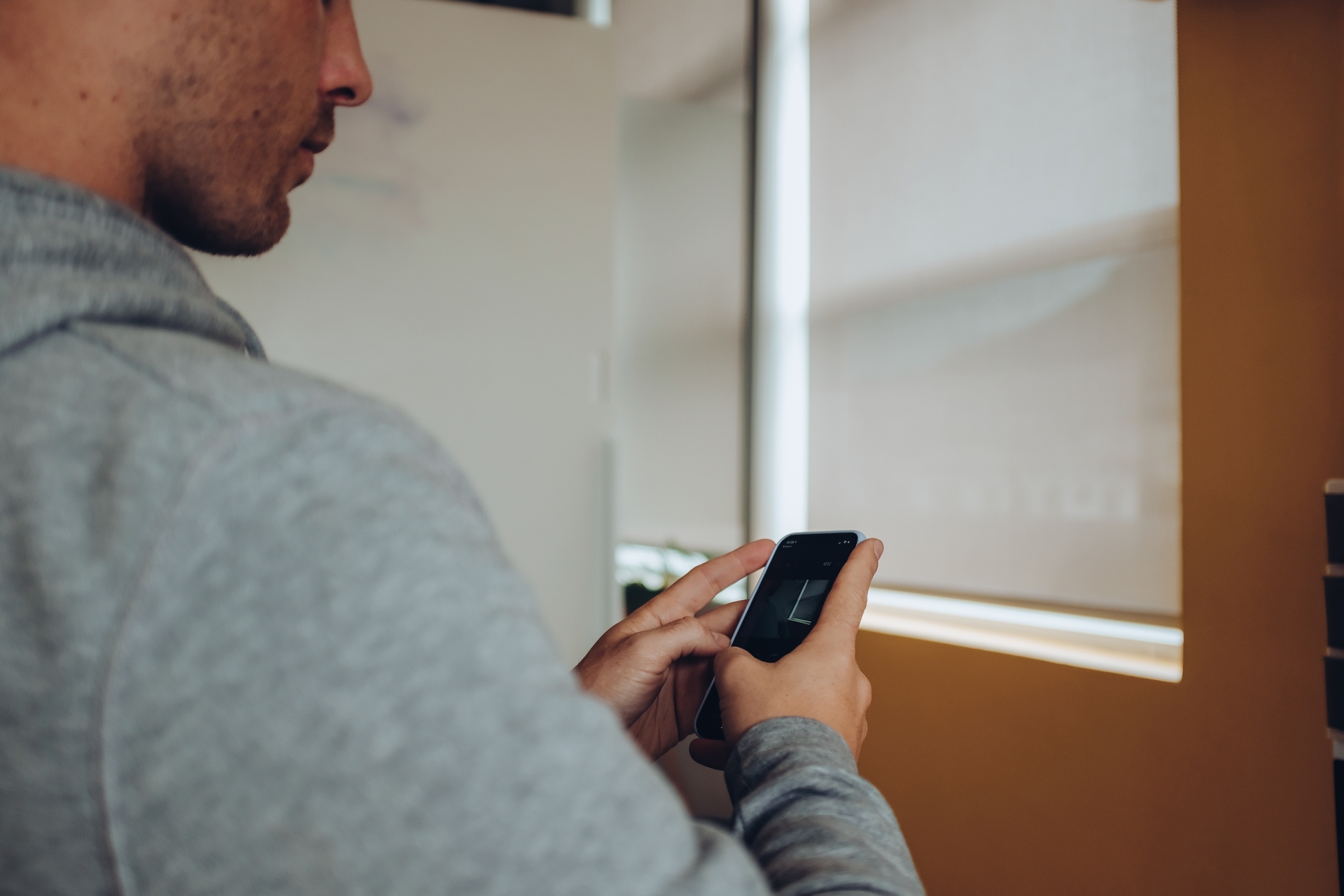 man holding smartphone using app at home