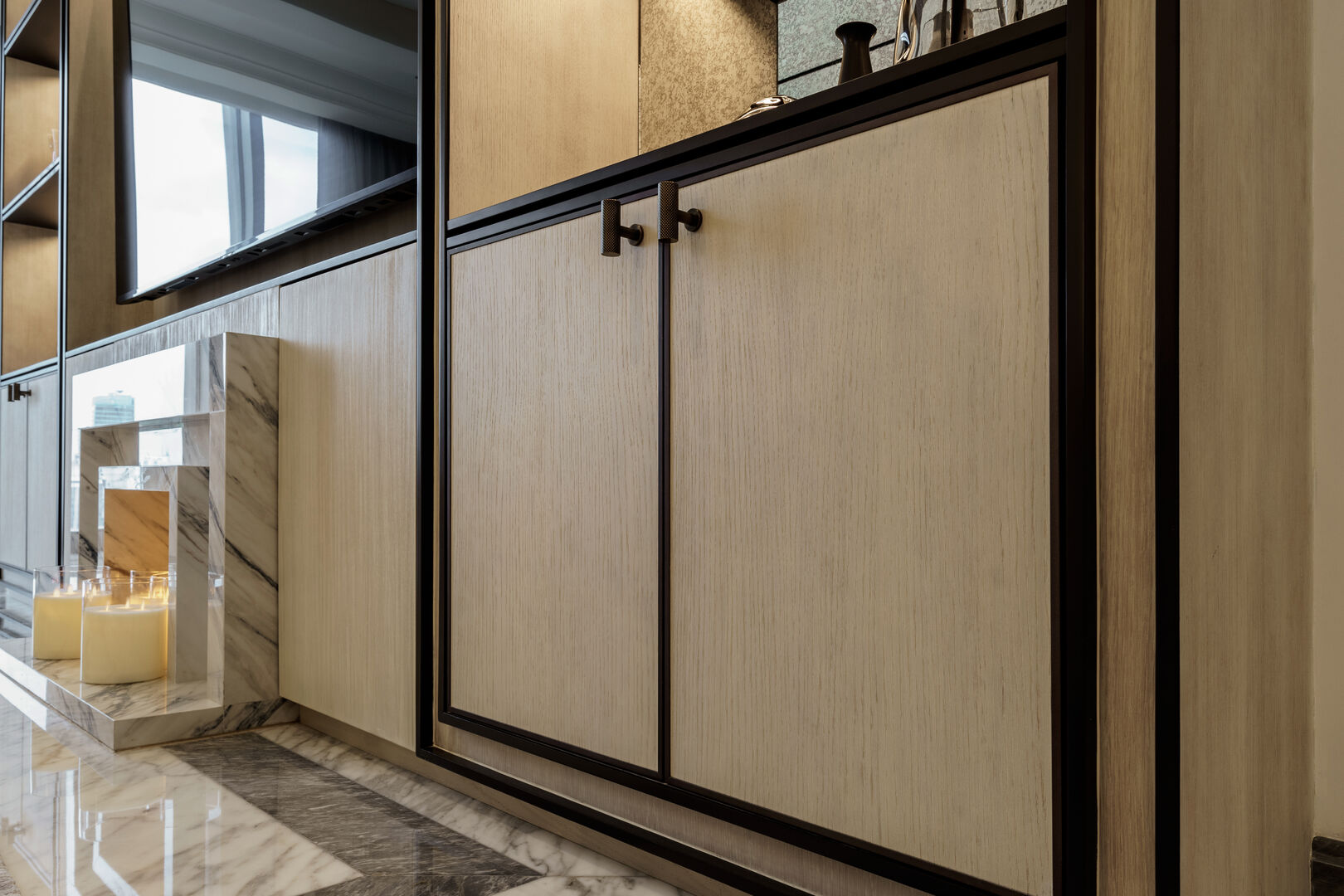 custom built-in cabinet featuring light wood grain doors with black metal frames and minimalist T-bar handles