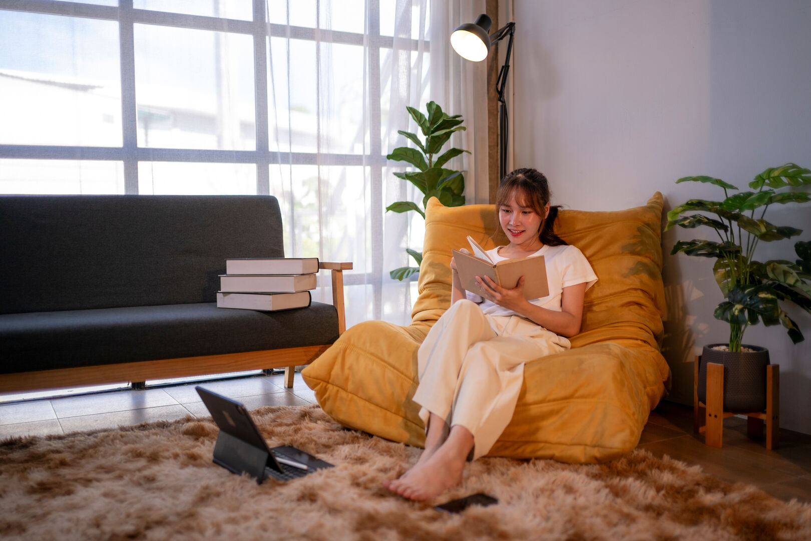 Young woman reading a book in cozy living room setting