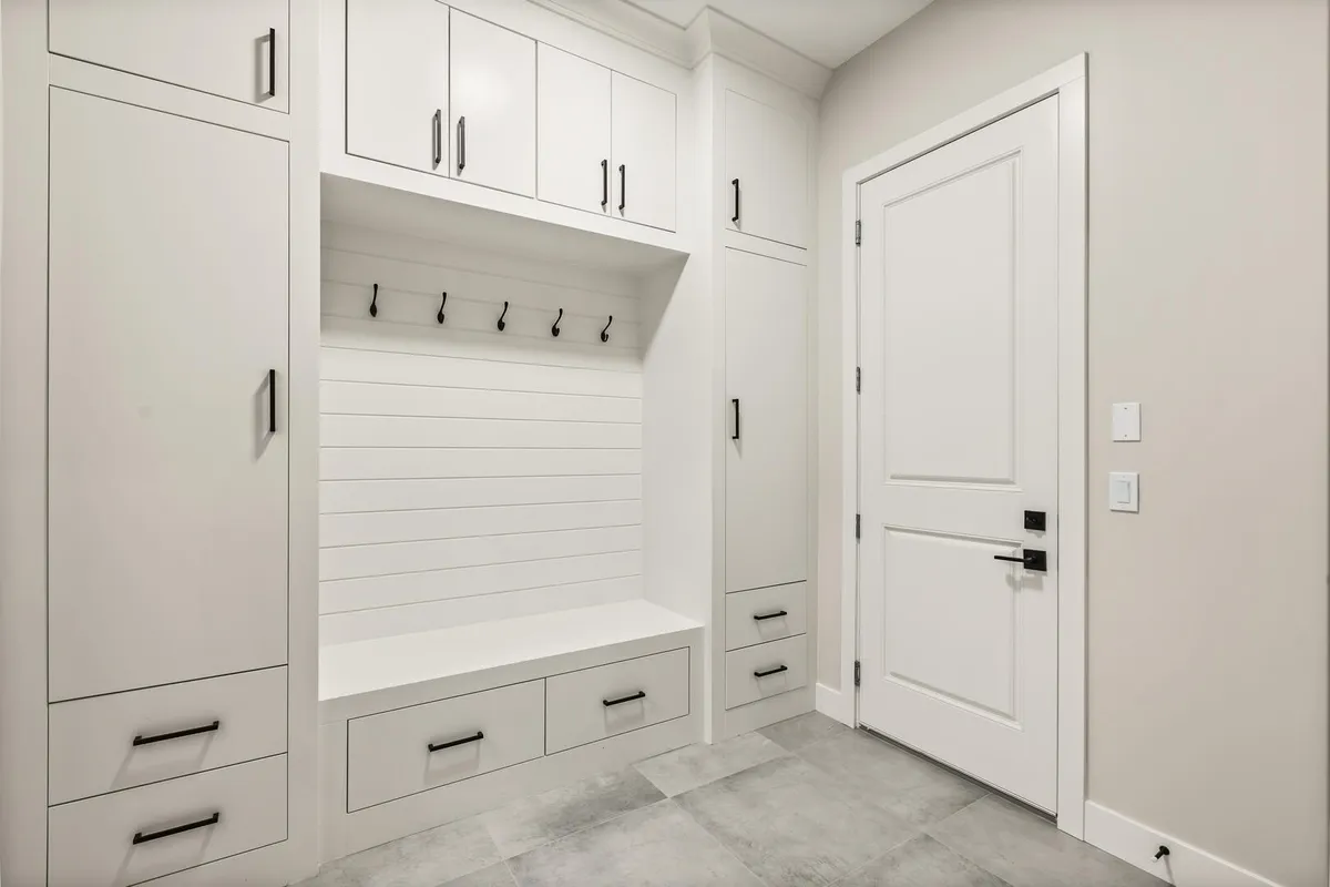 White custom mudroom storage with shiplap and black hardware