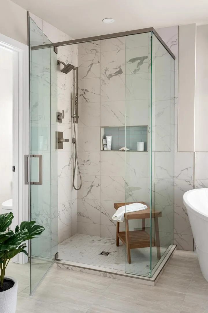 Clean modern glass shower with wooden bench