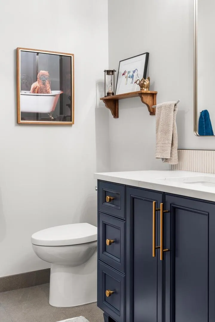Closeup of modern vanity with blue cabinet and brass pulls