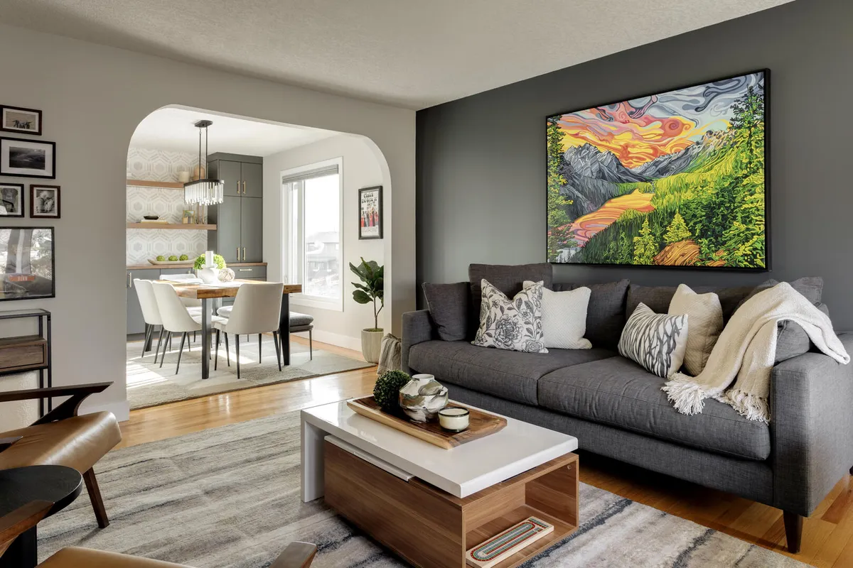 Blue and white living room with wood accents and leather sling chairs and colorful art