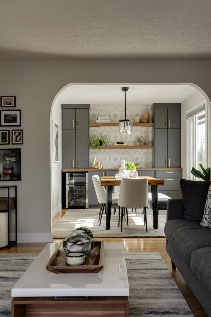 Archway architectural feature into light and bright dining room with blue grey built-ins and gold hardware