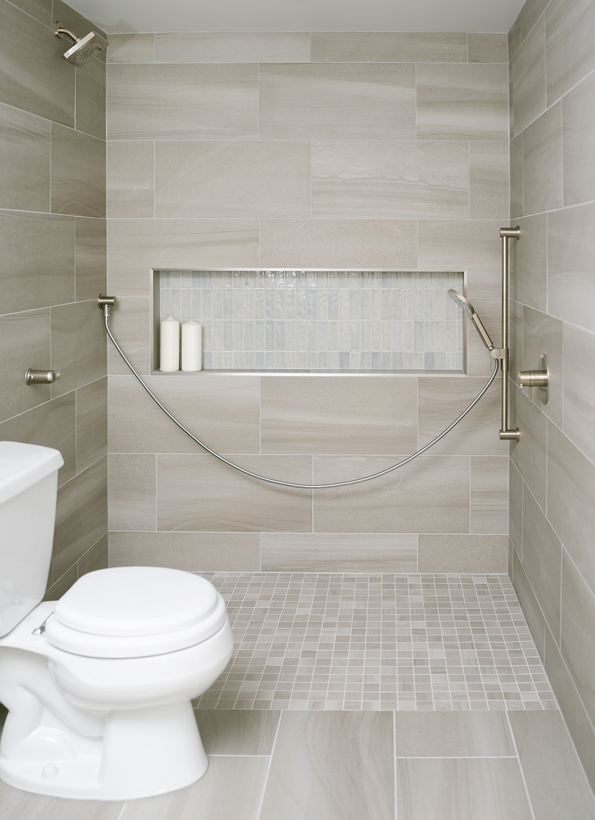 Roll in barrier free shower with large tiled niche and accessible shower controls