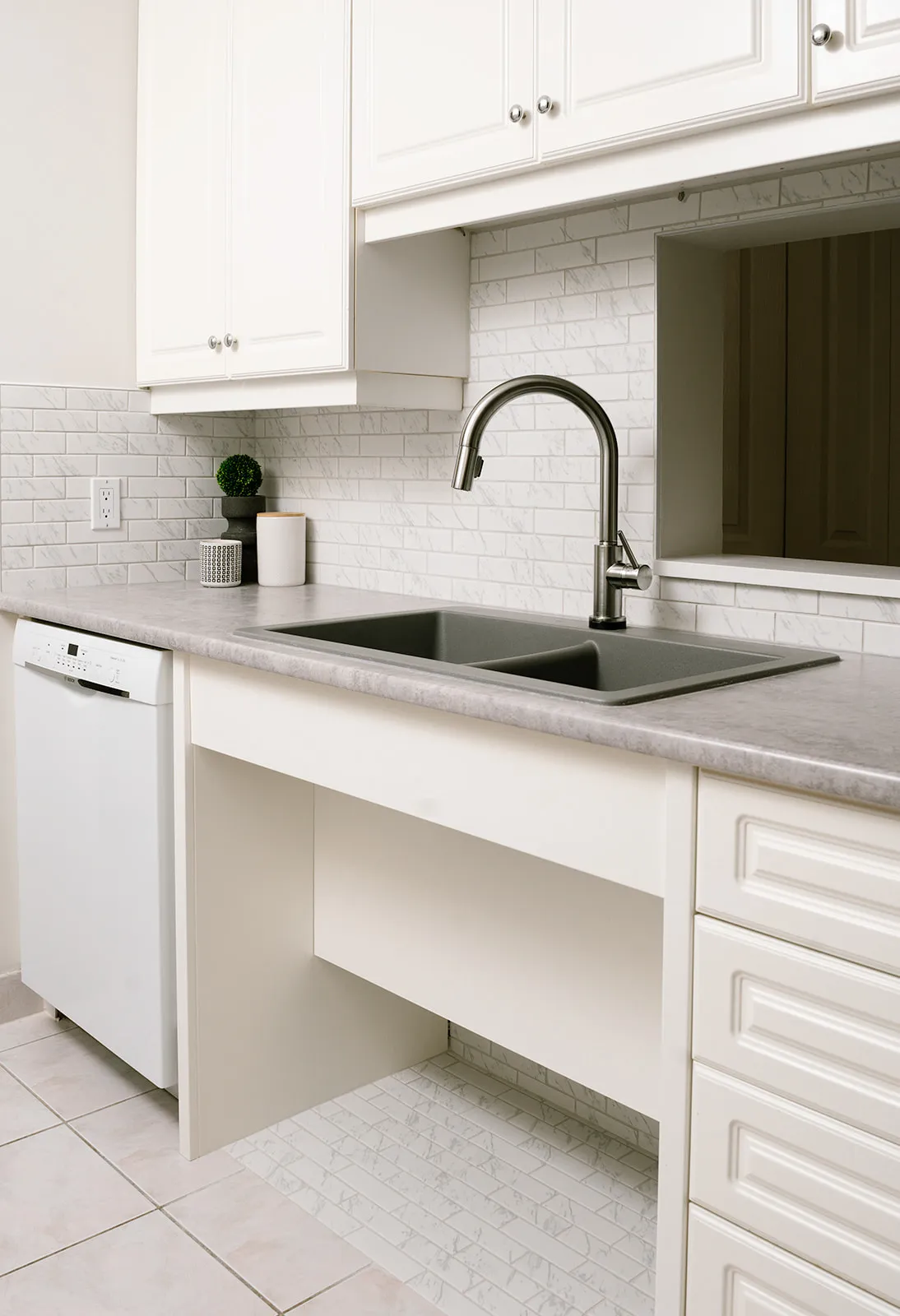 White and grey kitchen with accessible kitchen sink and motion sensor stainless steel faucet.