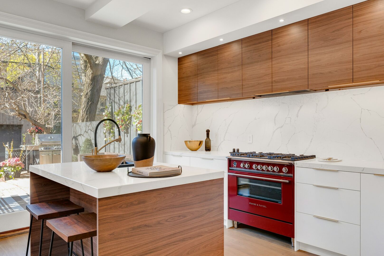 Two tone kitchen, white and wood cabinetry with red gas range