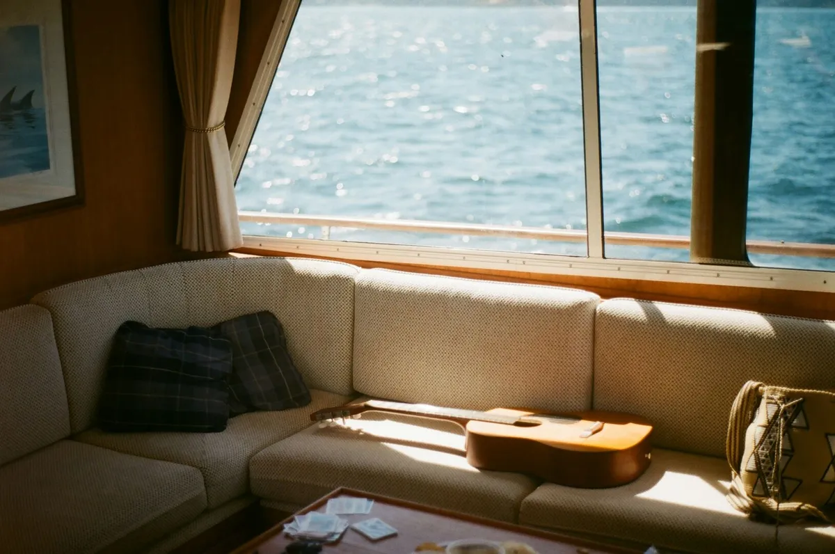 A beautiful modern houseboat bedroom with wood paneling and white bed