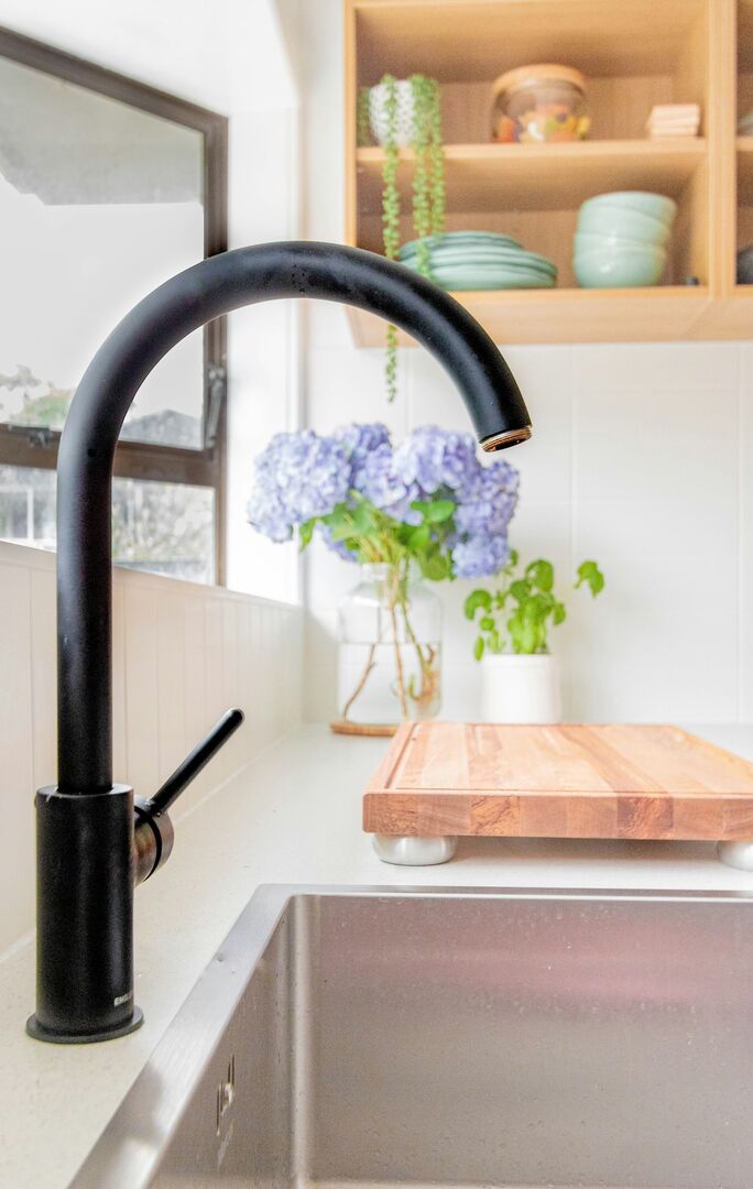 Modern kitchen with black faucet and white countertops