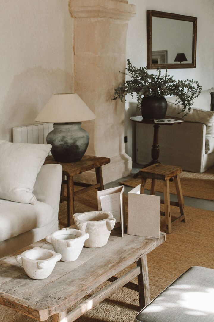 Bright living room with a white sofa beside a rustic wood table and a textured charcoal coloured table lamp.