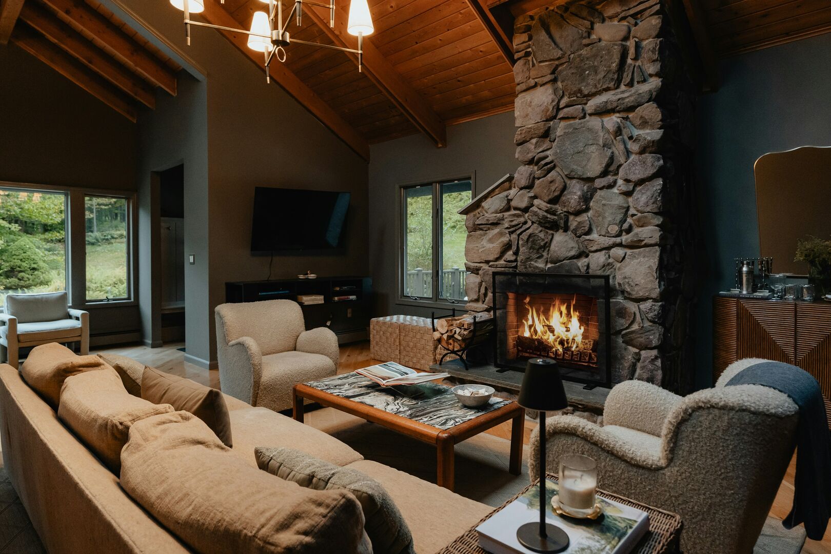 Living room in a rustic cabin with large stone fireplace. Dark rustic cabin living room.