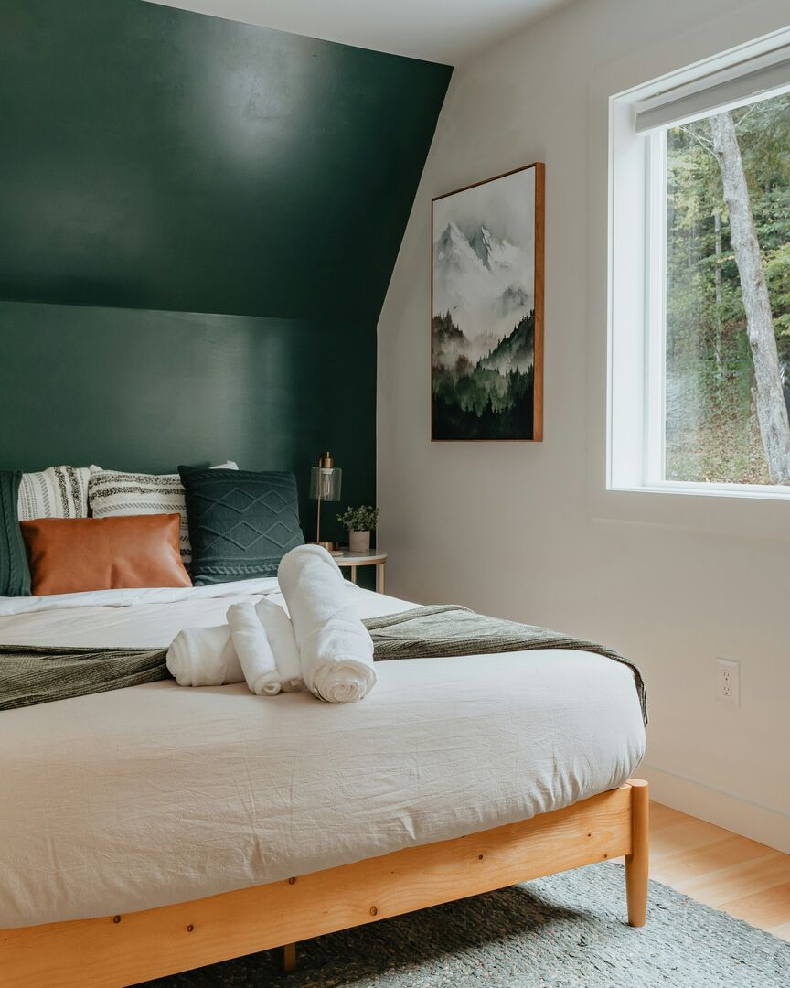 Modern cabin bedroom, green bedroom accent wall, airbnb cabin bedroom