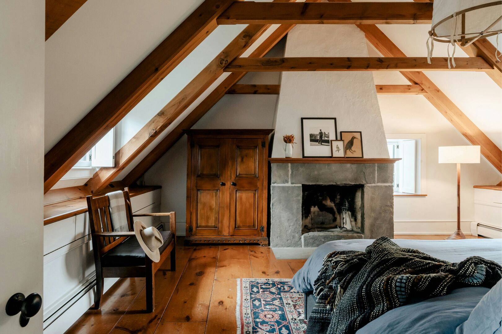 A frame ski cabin bedroom with stone wood burning fireplace