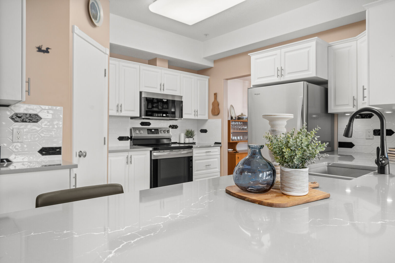 Light and bright white kitchen refresh, Cambria Clare countertops, white kitchen cabinetry and black hardware