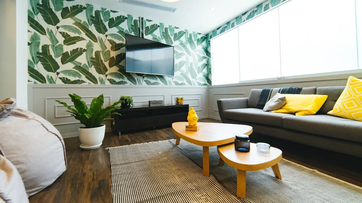 Light and bright living room with bold tropical wallpaper
