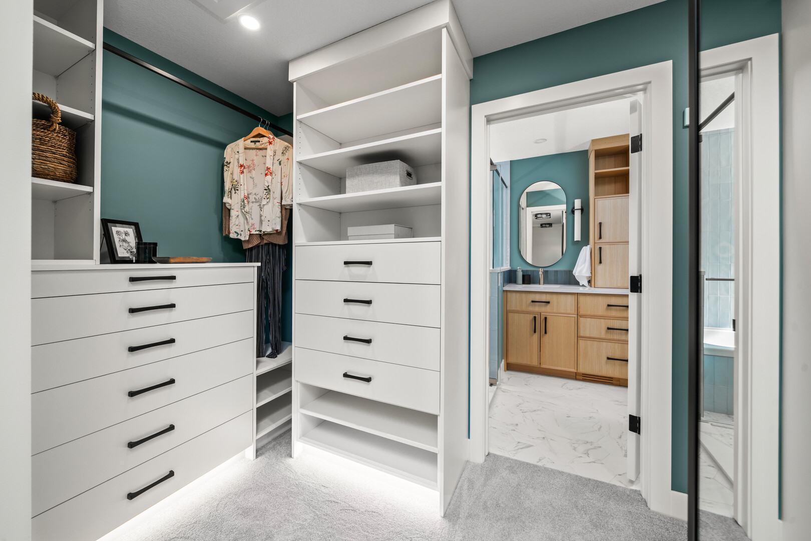 Clean modern home office with wood accents and wallpaper feature with blue chair