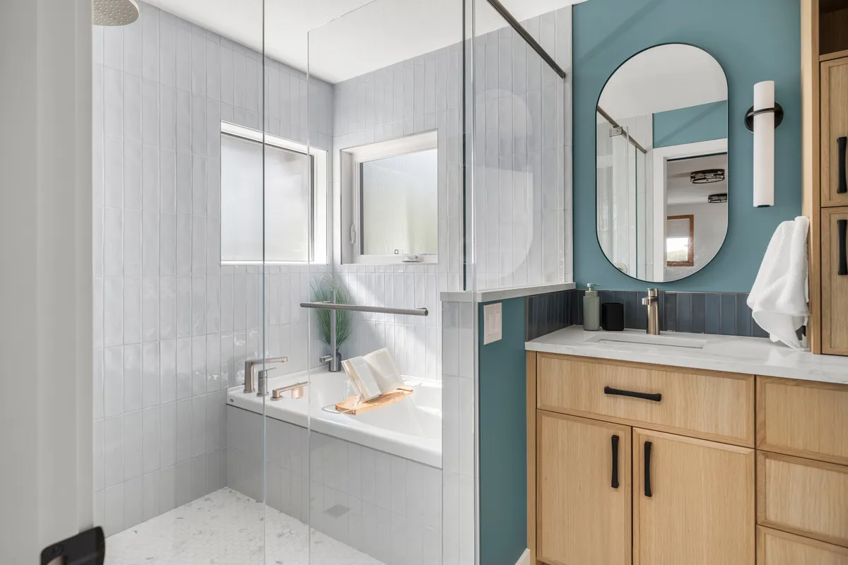 Ensuite bathroom with a glass shower, built-in bathtub, and light wood vanity