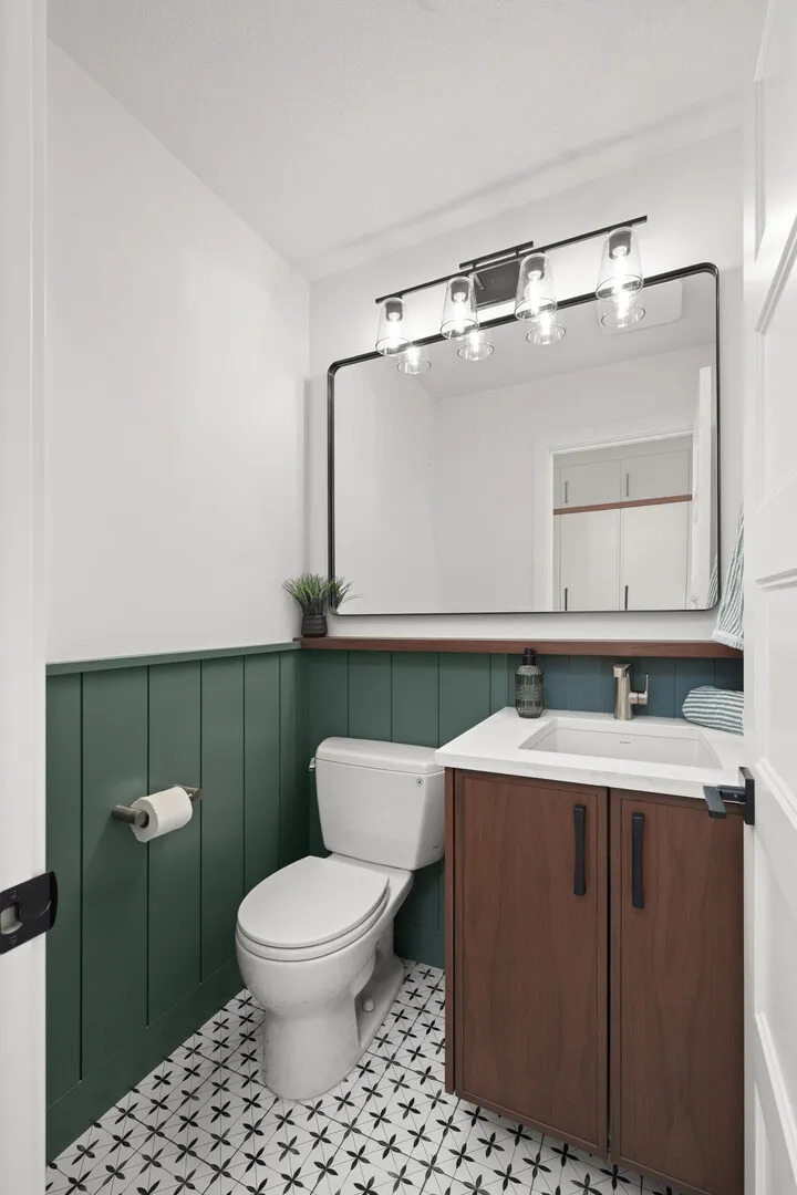 Walk-in closet with white built-ins and a view into the ensuite bathroom