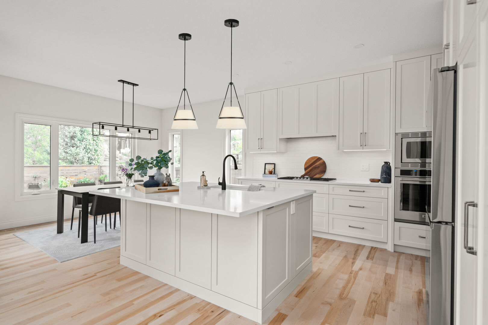White kitchen with a large island and adjacent dining area