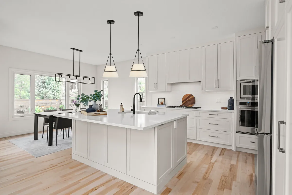 White kitchen with a large island and adjacent dining area