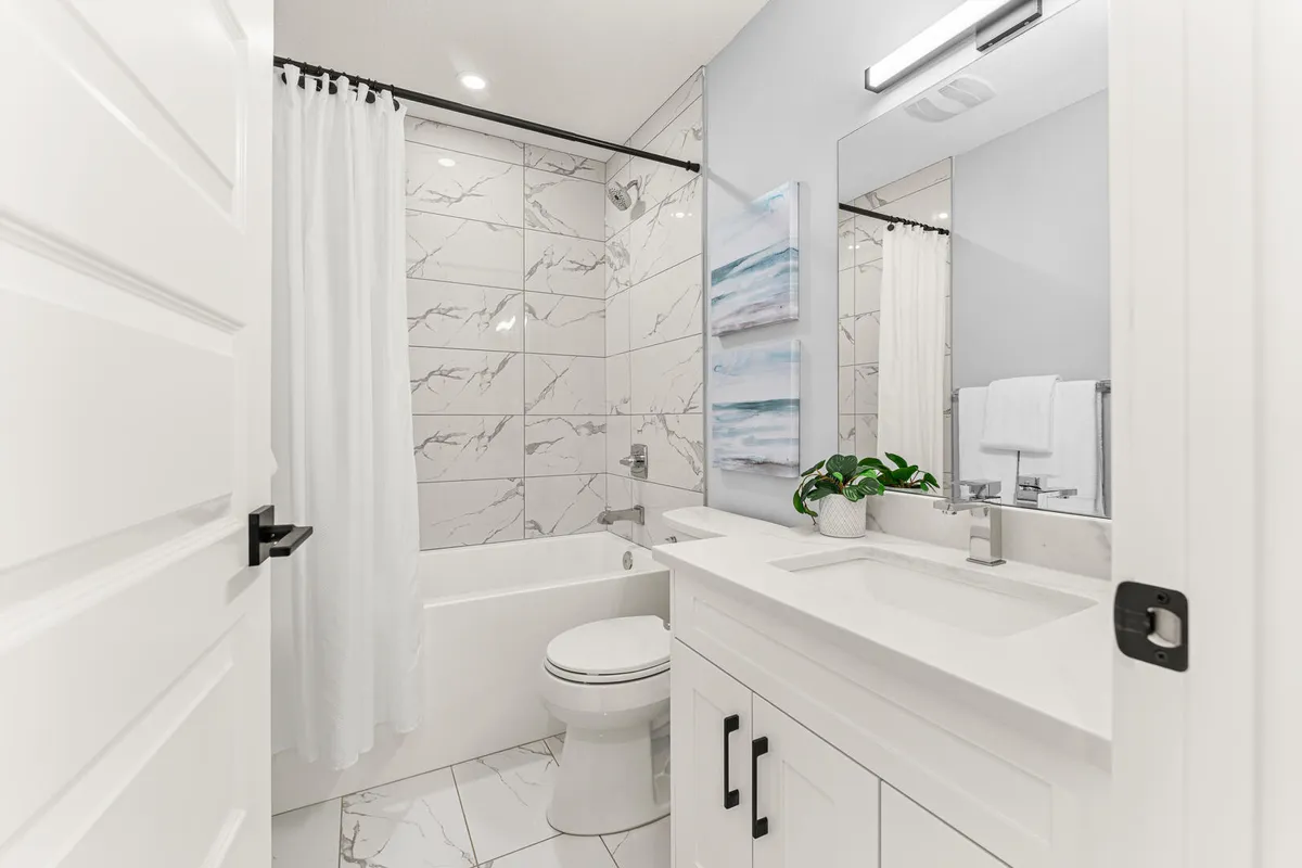 White modern bathroom renovation with large marble tiles