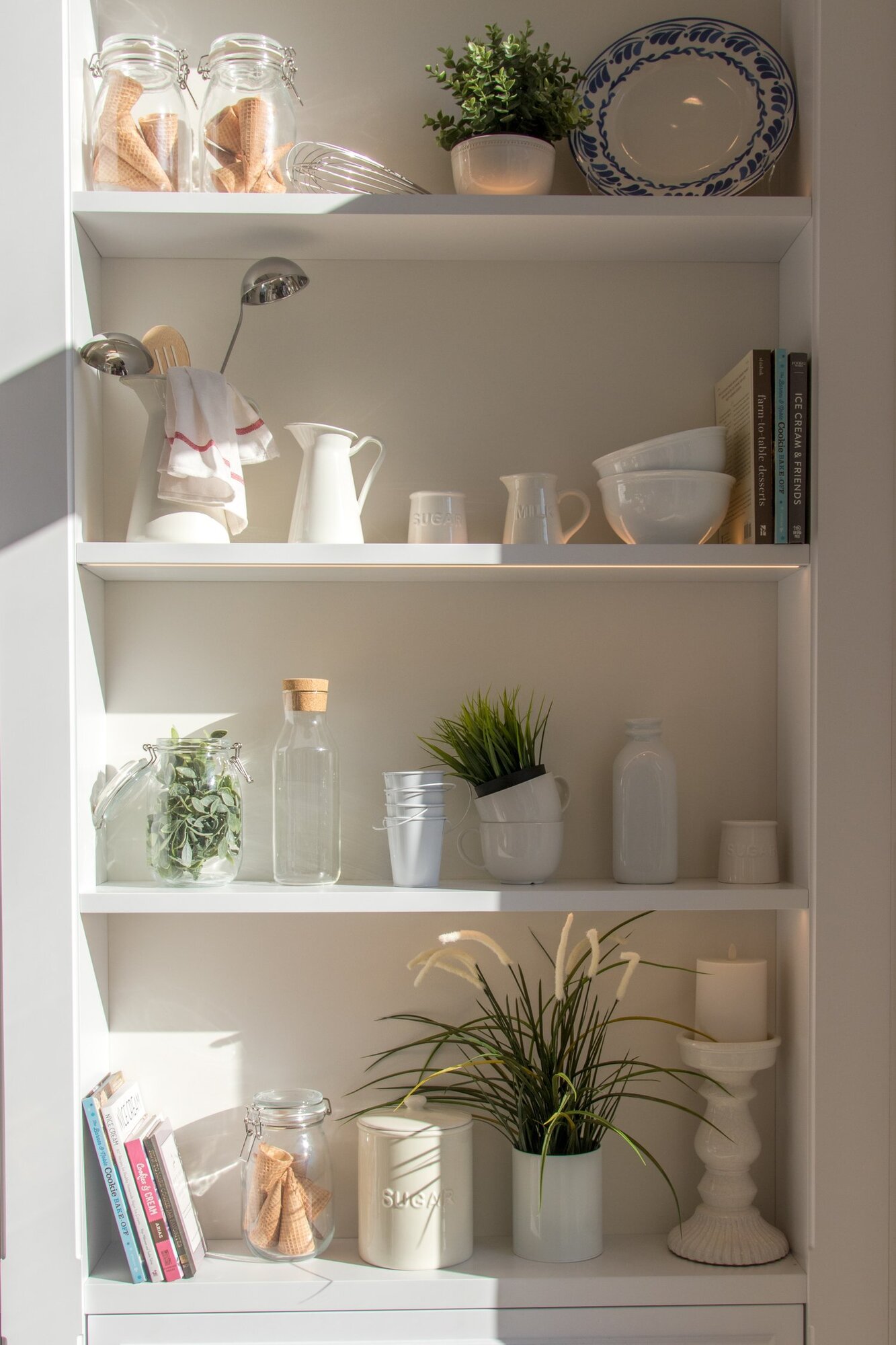 Light bright shelf with jars, bowls, and plates