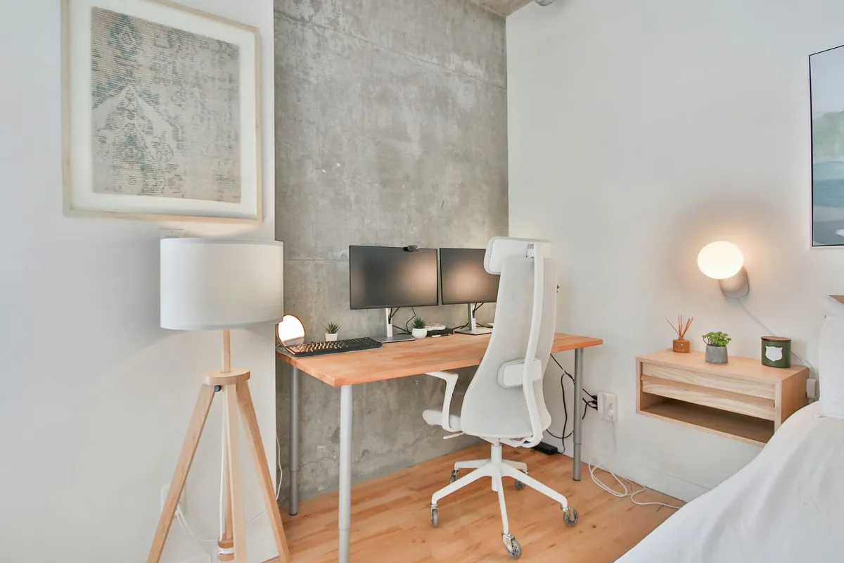 Modern minimalist home office in neutral colours with cement accent wall.