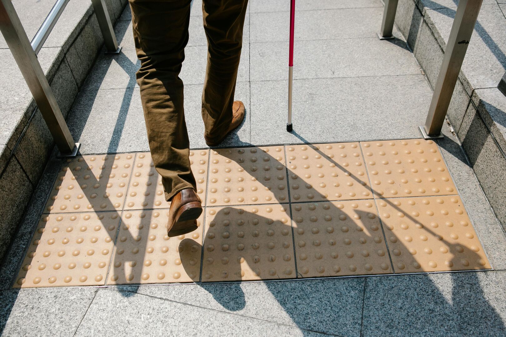 Outdoor accessible ramp with textile groundcovering for seeing impaired individuals.